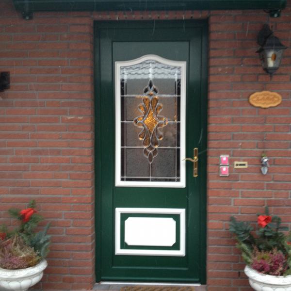 Haustür in grün mit Lichtausschnitt mit Verzierung und weißen Ausschnitten 